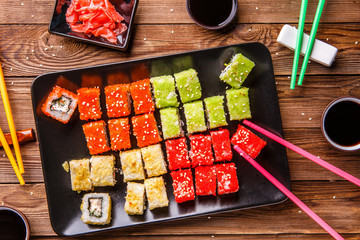 Sushi Set rolls with soy sauce served on black plate