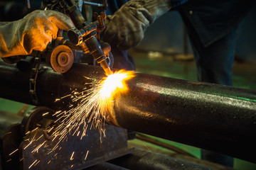 Acetylene torch cutting tube industrial for construction fabrication with bright sparks in steel...