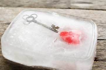 Heart and key frozen in a block of ice on the old boards