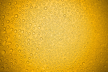 Water drops on yellow glass, Rain droplets on glass background.