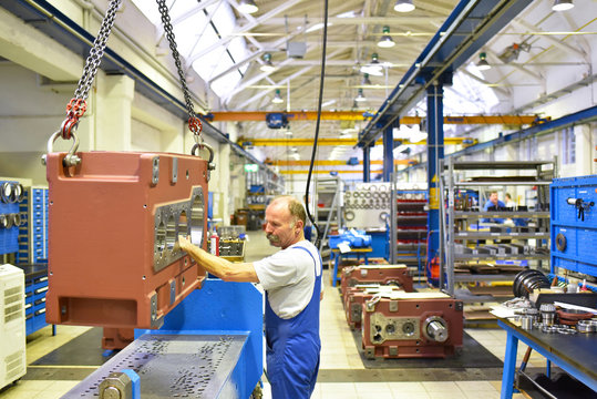 Arbeiter im Maschinenbau montiert ein Getriebe // Worker in mechanical engineering mounted a gearbox