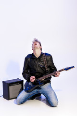 young expressive rock musician playing electric guitar and singing. Rock star 