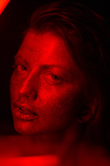portrait of beautiful young woman with red studio light