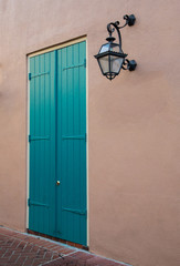 Stucco Building Wall With Blue Door And Porch Light