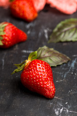 Fresh ripe strawberry on the rustic background. Shallow depth of field.