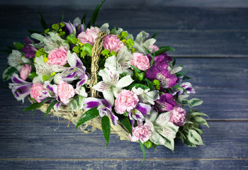 Wedding bouquet in basket on wooden background. Vintage toning