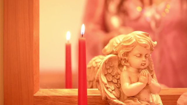 Woman's hand ignites the candle near a angel, for meditation