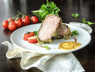 Grilled meat on white plate with tomatoes chives and dark hot sauce