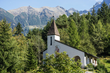 Fototapeta premium Saint Blasius church, wildlife and alps background. Piburg wild mountainous natural, Oetz, Austria, Europe