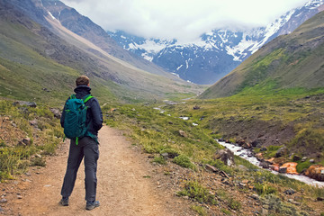 Fototapeta premium Mężczyzna z plecakiem w górach w pochmurny dzień