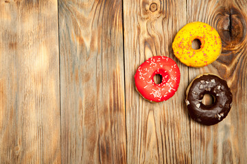 Colorful donuts on wooden background