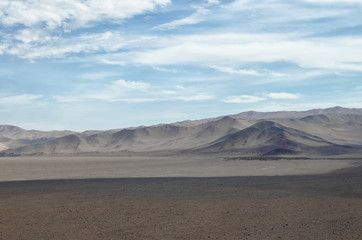 Fototapeta na wymiar View to brownish dry lands of desert under cloudy sky - stunning view