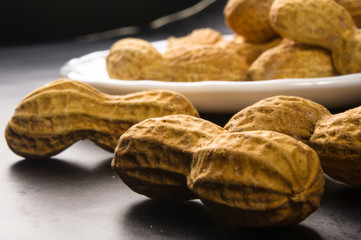 Peanuts in shell on dark background, close up