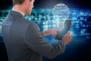Composite image of businessman using tablet