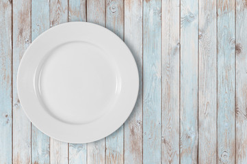 white empty dinner plate on left side of blue wooden table