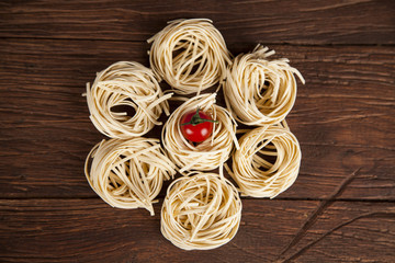 Dry pasta with ingredients on a old wood