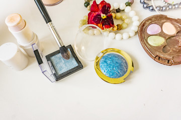 Close-up of makeup, foreground, shade, blush and powder, bracelets from pearls and natural stones. Copy space.
