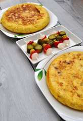Potato tortillas on a plate and spicy vegetables for lunch