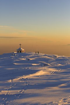 Hikers at the  Military war memorial on the summit of Monte Grappa at sunset, Italy