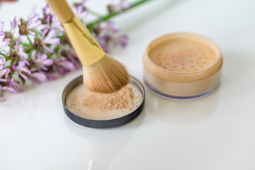 Close-up of mineral, powder, foundation makeup and brush to apply the product. 