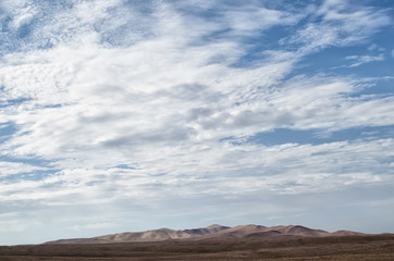 View to brownish dry lands of desert under cloudy sky