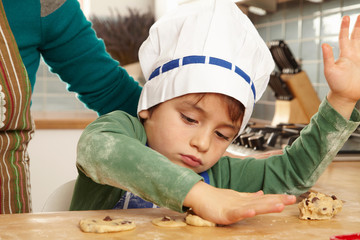 Young boy making cookies in kitchen