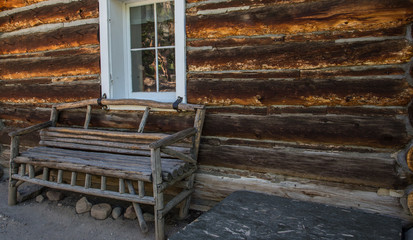 Wooden Bench By Log Cabin