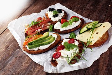 Bread Brushetta or authentic traditional spanish tapas set for lunch table. Sharing antipasti on party or summer picnic time over wooden rustic background.