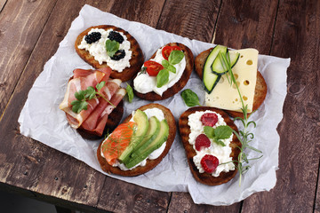 Bread Brushetta or authentic traditional spanish tapas set for lunch table. Sharing antipasti on party or summer picnic time over wooden rustic background.