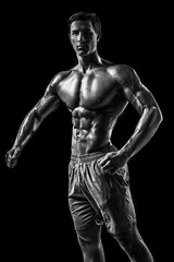 Fototapeta na wymiar Muscular and fit young bodybuilder fitness male model posing ove