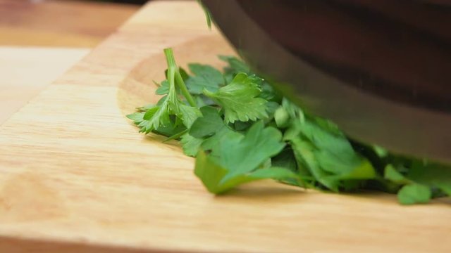 sliced green parsley on a wooden board with a special knife