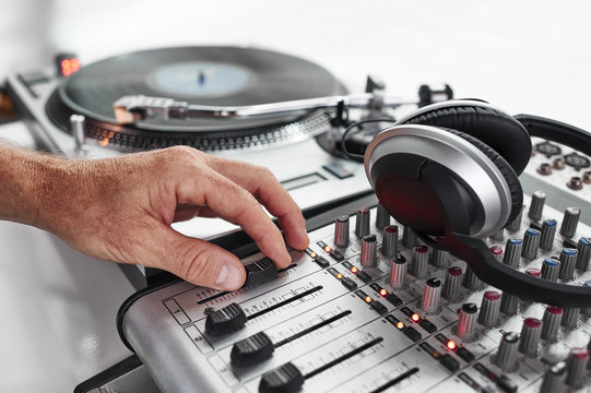 a dj playing records and using a mixing board