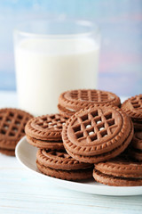 Chocolate cookies with glass of milk on wooden table