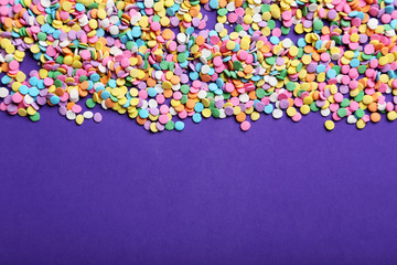 Colorful sprinkles on the purple background