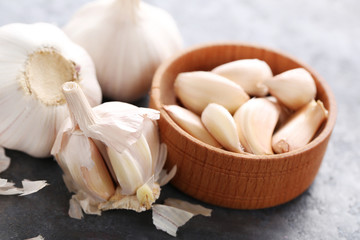 Garlic in bowl on grey wooden table