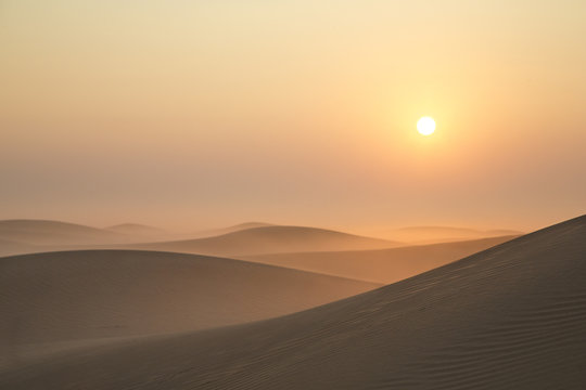 Gouden zonsopgang boven mistige woestijnduinen