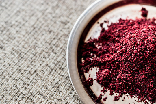 Dried Sumac, sumah or sumak on silver plate (arabic cuisine)