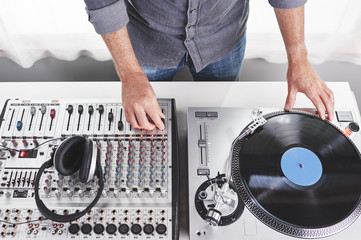 a dj using a turntable and mixing board