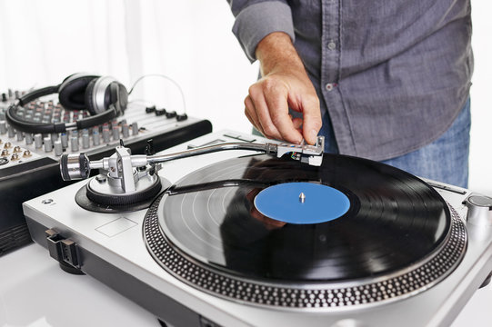 a dj using a turntable and mixing board