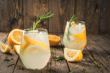 Summer refreshments. Detox water. Lemonade. Tonic with ice, lemon and rosemary, on an old wooden...