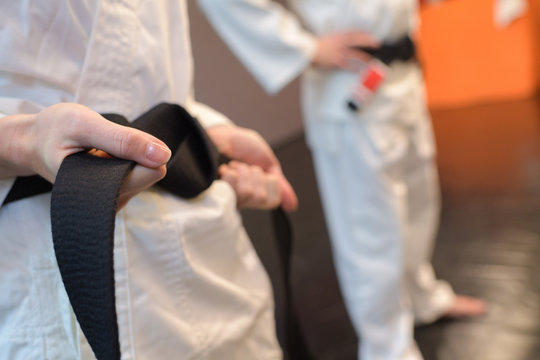 Closeup of black belt being secured around kimono