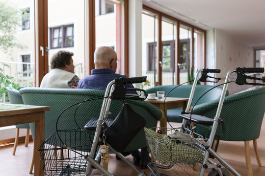 Man and woman, both seniors, couple, sitting on couch in retirement home having coffee