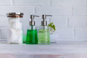 Part of spa interior. Cotton napkins, cotton pads, tissue, towels, soap and cosmetic products on a wooden table. White  background and table. Copy space.