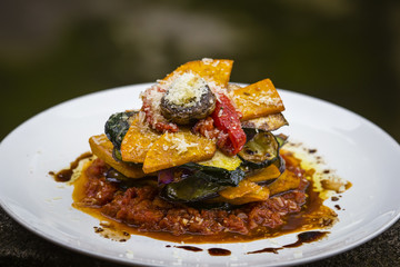 Vegetable stack - pumpkin, zucchini, red capsicum, eggplant and mushroom cooked in a tomato, onion, and garlic sauce topped with parmesan cheese