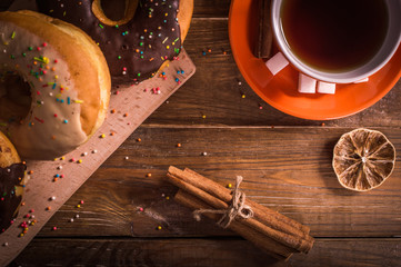 Donuts and tea on a wooden background