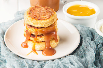 Cottage cheese pancakes on a wooden white background, horizontal, selective focus
