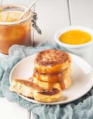 Cottage cheese pancakes on a wooden white background, vertical, selective focus
