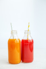 Strawberry and orange juice. The glass bottle. White background. The concept of beverages, health food and vegetarian.