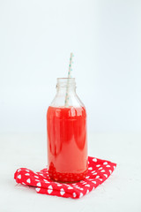Grapefruit juice is delicious. The glass bottle. White background. The delicious strawberry juice in a glass bottle. The concept of beverages, health food and vegetarian.