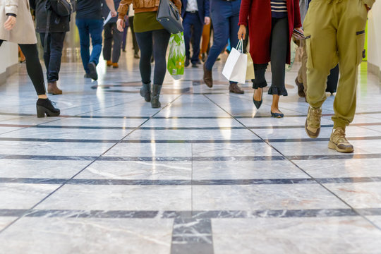 A modern floor with legs of a crowd in the background in Canary Wharf, London